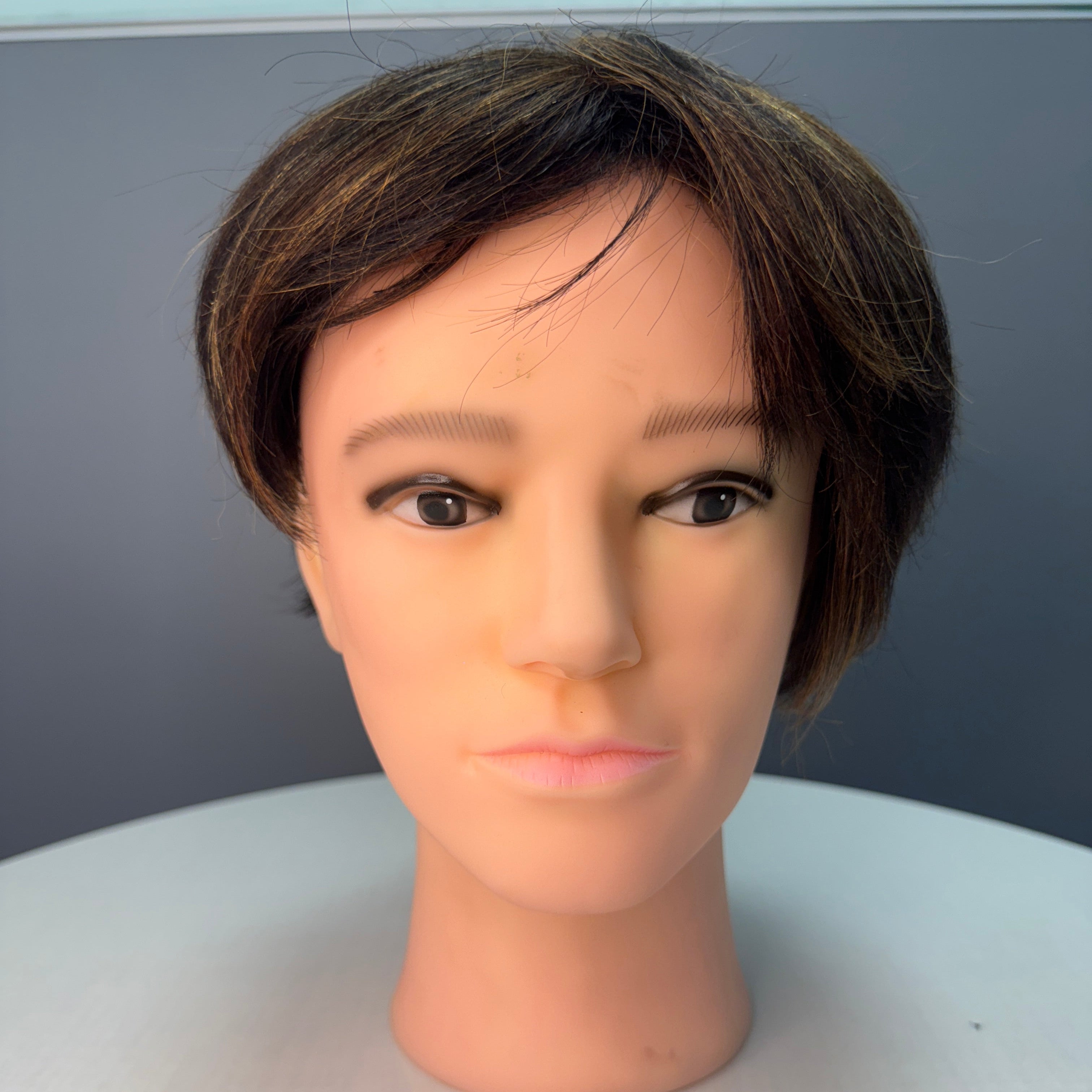 Mannequin head with human-like face on a gray background