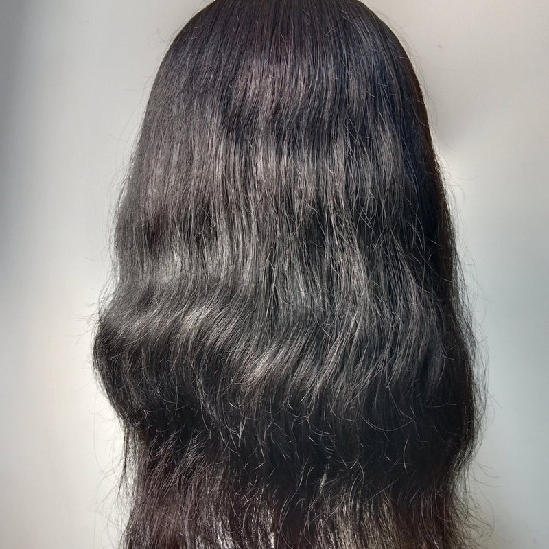 A crown topper worn over a person's own hair, seen from behind